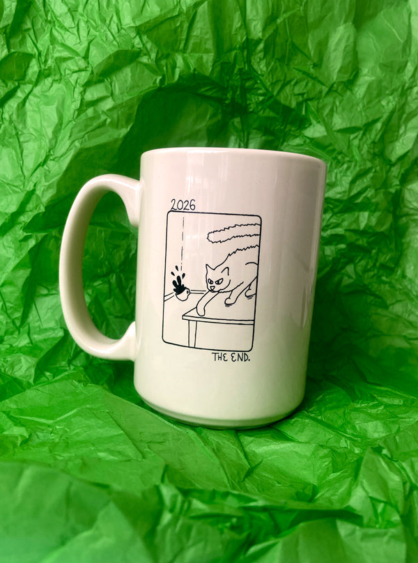 A beige ceramic coffee mug with a black line art illustration of a cat swiping a cup of coffee, set against a crumpled bright green background.