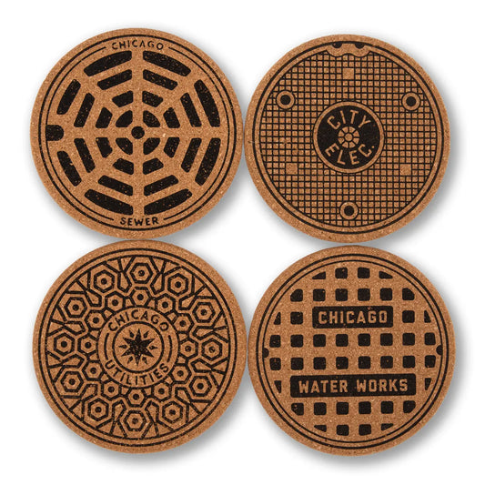 Four round cork coasters featuring Chicago manhole cover designs, arranged in a 2x2 grid on a white background.